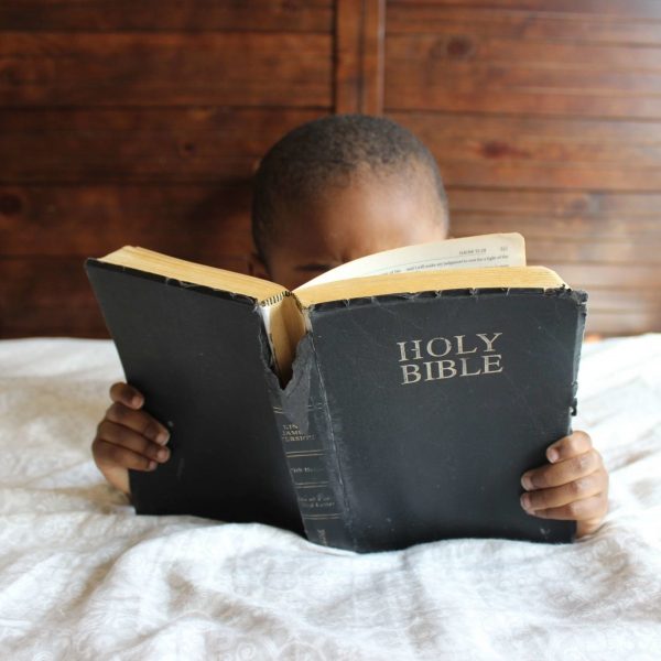 photo-of-child-reading-holy-bible-935944